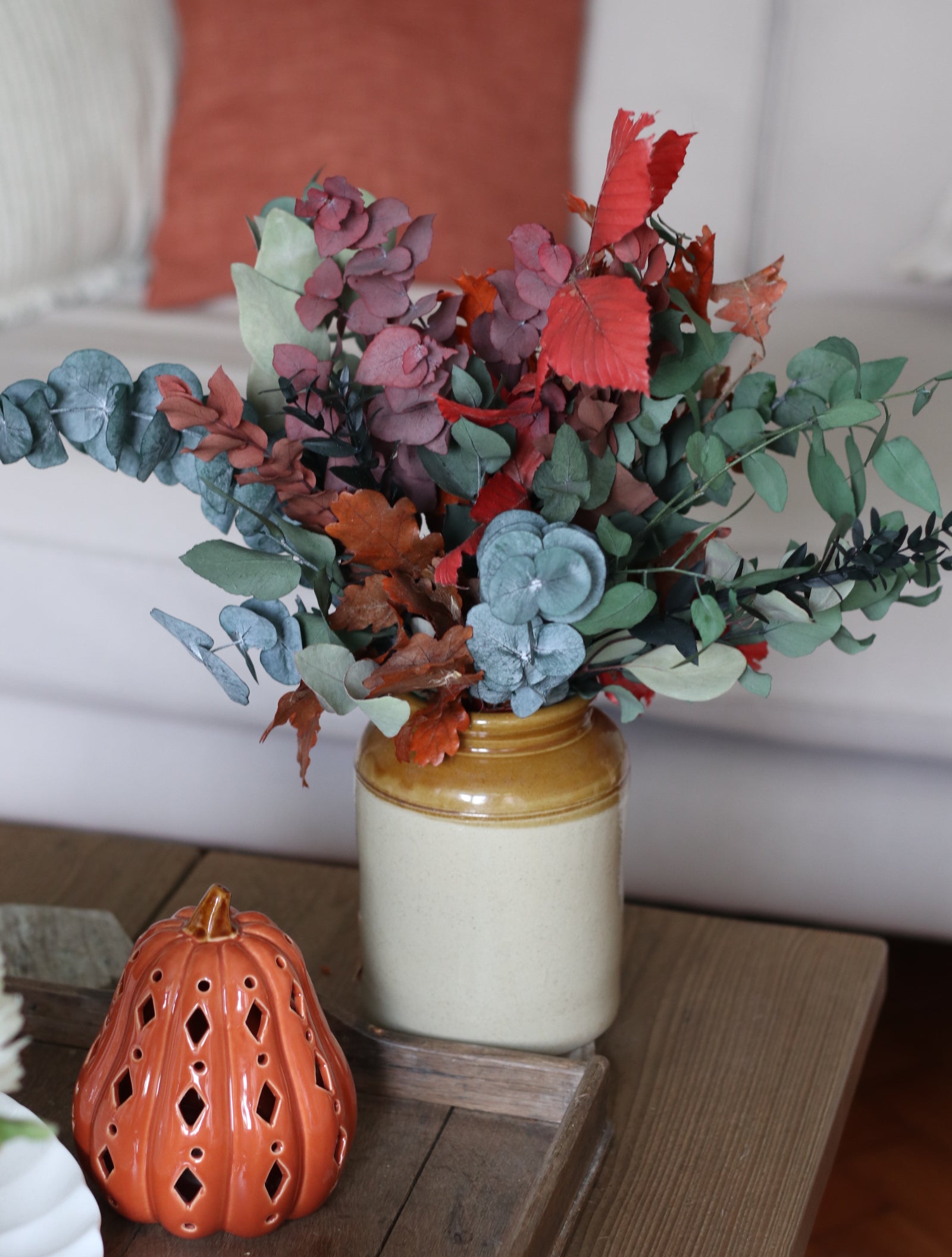 Decorative arrangement of artificial flowers in a vase on a table.