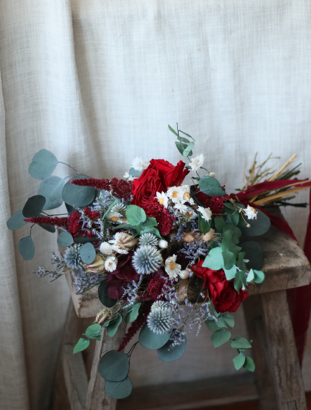 Bouquet of red and green flowers on a textured surface