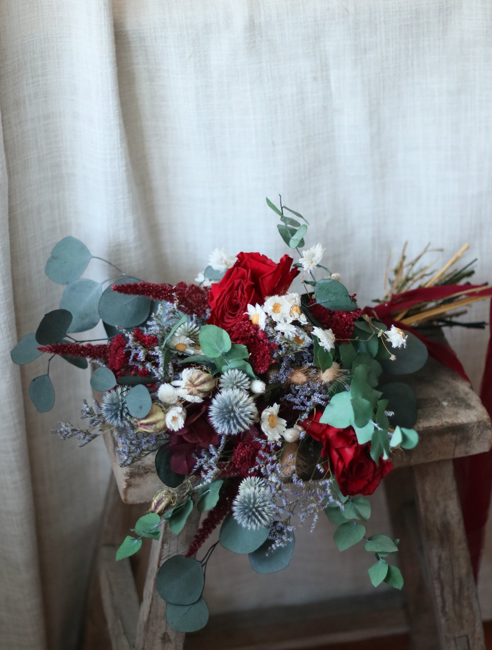 Bouquet of red and green flowers on a textured surface