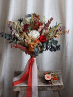 Bouquet of dried preserved flowers with, orange, peach and green dried flowers, perfect for an autumn wedding.
