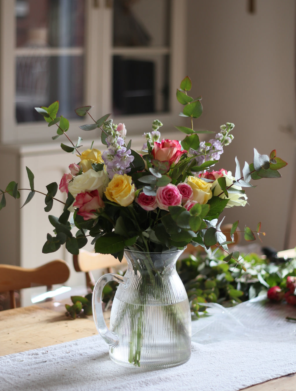 Bouquet of flowers with a watering can in a home setting