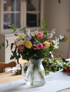 Bouquet of flowers with a watering can in a home setting