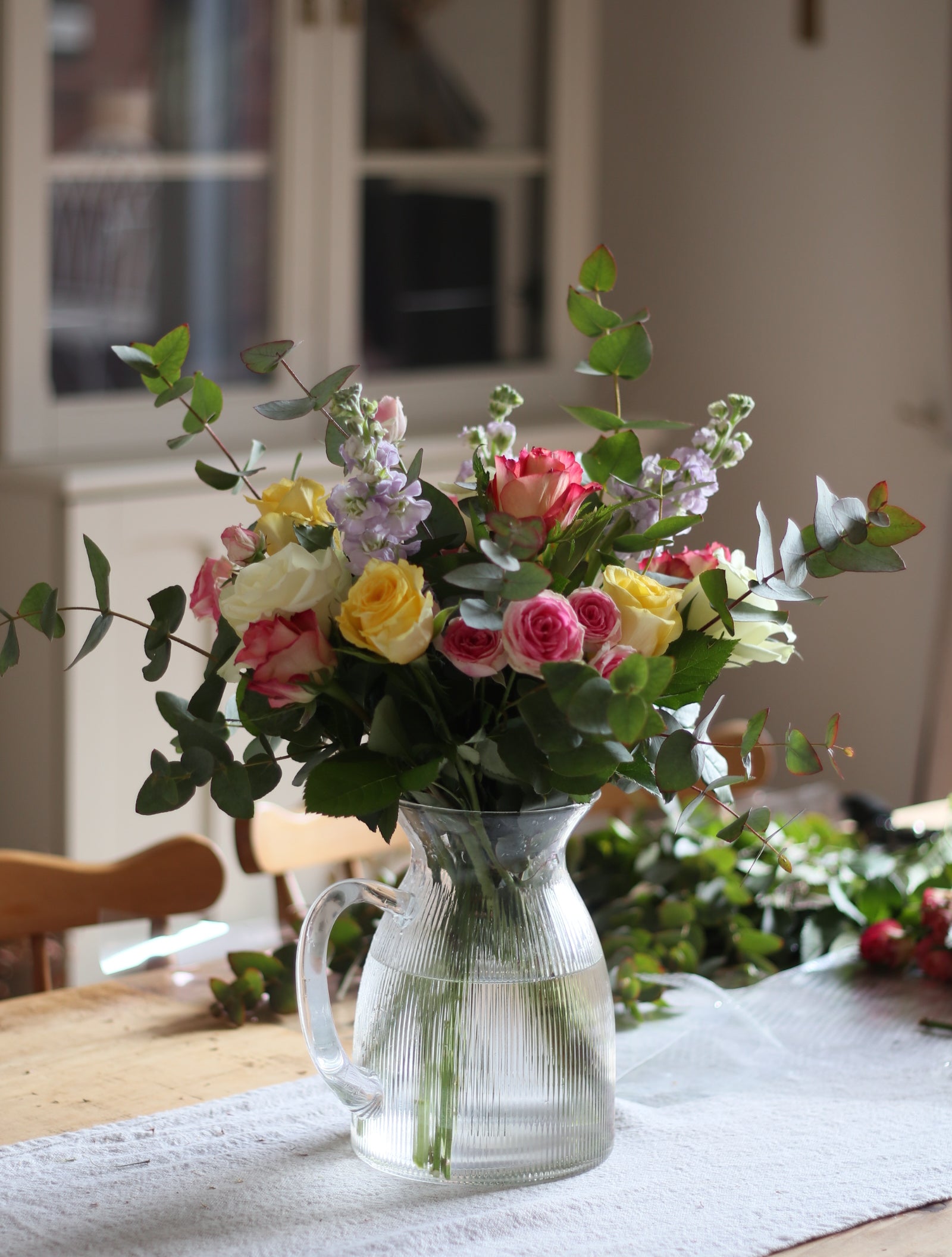 Bouquet of flowers with a watering can in a home setting